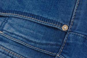 partie du pantalon en jean bleu avec poches et rivets, gros plan photo