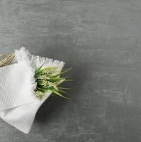 serviette douce avec une fleur dans un fond de stuc décoratif gris. vue de dessus, isolé photo