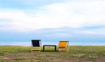 chaises longues vides de belle couleur sur le manteau de plage avec fond de ciel bleu. vacances abstraites joyeuses fêtes photo