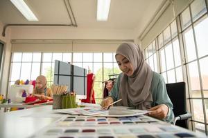 les femmes musulmanes dirigent une petite entreprise dans leur propre maison. est la conception et la confection de vêtements. photo