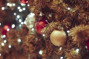 sapin de noël décoré sur fond flou. décoration de Noël. boules rouges suspendues sur des branches de pin guirlande d'arbre de noël et ornements sur fond abstrait bokeh with copy space
