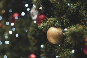 sapin de noël décoré sur fond flou. décoration de Noël. boules rouges suspendues sur des branches de pin guirlande d'arbre de noël et ornements sur fond abstrait bokeh with copy space