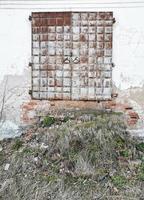 anciennes portes du monastère avec un escalier en ruine.les murs délabrés étaient envahis par l'herbe.porte en métal. photo