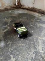 Voiture jeep verte miniature sur fond de mur en bois sale photo