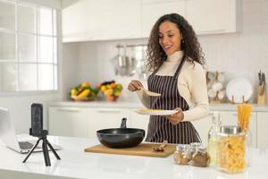 femme latine filmant une vidéo et cuisinant dans la cuisine photo