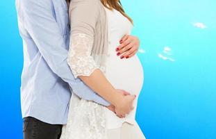 portrait de jeune couple en attendant l'enfant isolé sur fond bleu, jeune couple attrayant mère enceinte et père heureux, beau jeune couple attendant bébé photo