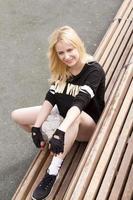 la fille est assise sur le banc du terrain de football avec le ballon. photo