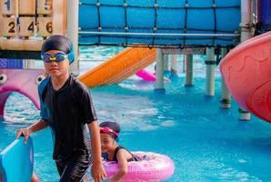 les enfants s'ébattent au parc aquatique. c'est une journée ensoleillée, parfaite pour se mouiller et jouer dur photo