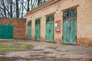 un long hangar en briques avec de nombreuses grandes portes en bois. ancien service d'incendie photo