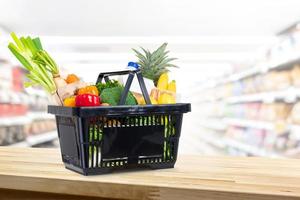 panier plein d'épicerie sur le comptoir en bois en arrière-plan du supermarché photo