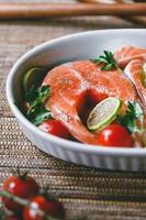 steaks de saumon frais au citron vert, tomates cerises, persil et huile d'olive. concept de dîner ou de déjeuner sain.