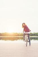 pieds de femme vélo à pédales sur le pont en bois regardant la caméra, liberté relaxante, prêt à rouler. photo