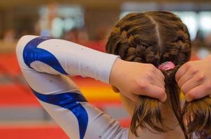 jeune fille gymnaste fixant les cheveux avant l'apparition photo