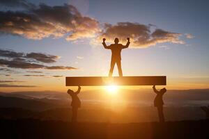 silhouette homme réussi au sommet de la colline et le coucher du soleil photo