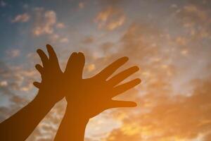 silhouette avec les mains en forme d'oiseau sur le ciel coucher de soleil pour le fond. photo