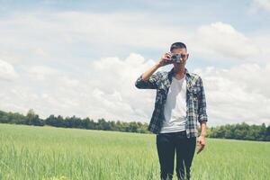 jeune hipster bel homme photographie debout prise de vue appareil photo rétro avec nature profiter et heureux dans les prairies.