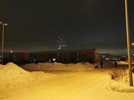 feux d'artifice du nouvel an dans le village de chalets par une nuit d'hiver photo