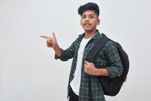 beau garçon de collège indien pointant avec la main sur fond blanc. photo