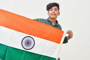Jeune homme indien tenant le drapeau national indien à la main sur fond blanc photo