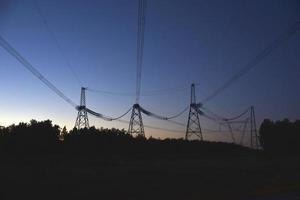 ligne à haute tension le soir dans la forêt photo