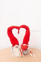 Deux gnomes amoureux en casquettes rouges avec une forme de coeur sur un format vertical de fond blanc photo