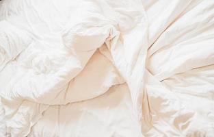 vêtements de lit blancs en désordre haute résolution .couverture blanche désordonnée, drap de lit défait après le réveil le matin texture. photo
