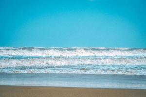 vague douce avec bulle d'océan bleu sur sable blanc à la plage tropicale en été. fond de plage simple pour l'été. bulle bleue vague de la mer au sable sur la plage. fond d'été.
