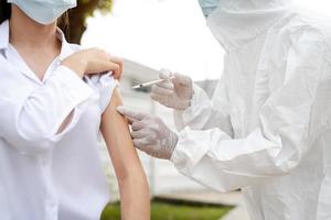médecin tenant une seringue avant de faire une injection au patient dans un masque médical. vaccin covid-19 ou coronavirus photo