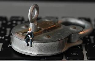 concept de sécurité internet-homme d'affaires miniature debout sur l'ancienne clé et cadenas sur le clavier de l'ordinateur portable photo