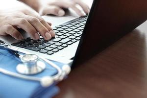 gros plan de la main du médecin à l'aide d'un ordinateur portable au bureau photo