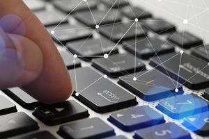 Close up of businessman doigt utiliser clavier ordinateur portable avec diagramme de médias sociaux virtuels comme concept photo