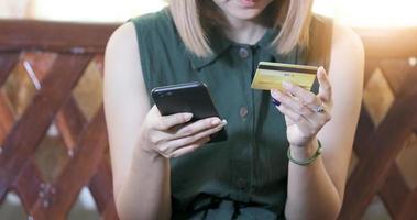 femme asiatique utilisant un smartphone et une carte de crédit faisant des achats en ligne photo