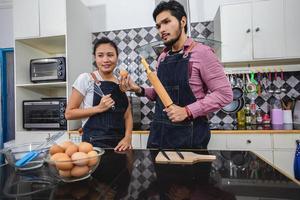 jeune couple heureux et souriant cuisiner des aliments dans la cuisine à la maison photo