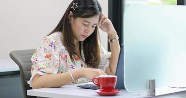 femme d'affaires asiatique sérieuse au sujet du travail et utilisant un ordinateur portable pour les partenaires commerciaux discutant de documents et d'idées lors d'une réunion