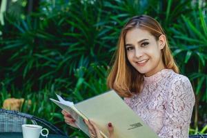 menu ouvert de femme asiatique pour commander dans un café-café et un restaurant et souriant pour un moment heureux photo