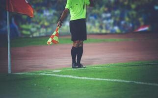 arbitre de football adjoint et drapeau d'arbitre au stade de football photo