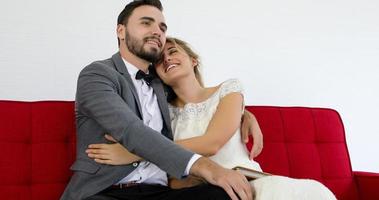 les amoureux donnent des fleurs à la mariée et s'embrassent heureux et le couple aime debout dans le studio de mariage photo