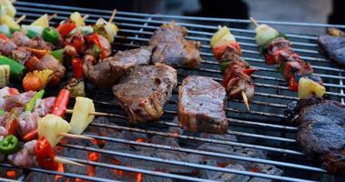 groupe d'amis asiatiques ayant un barbecue de jardin en plein air riant avec des boissons alcoolisées à la bière la nuit photo