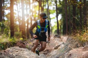 un homme coureur de trail. et pieds d'athlète portant des chaussures de sport pour courir en forêt