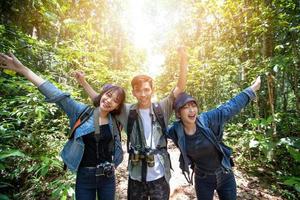 groupe asiatique de jeunes avec des amis et des sacs à dos marchant ensemble et des amis heureux prennent des photos et des selfies, détendez-vous pendant les voyages de concept de vacances