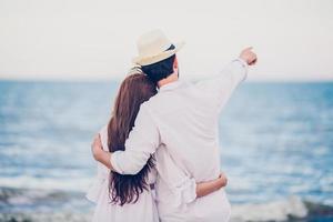 amoureux des couples romantiques heureux se tenant la main ensemble marchant sur la plage photo