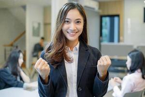 succès des femmes d'affaires asiatiques et concept gagnant - équipe heureuse avec des mains levées célébrant la percée et les réalisations photo