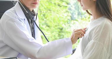 médecin utilisant un stéthoscope pour examiner le patient dans son bureau dans les hôpitaux photo