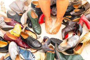 pieds nus au milieu de nombreux types de chaussures photo