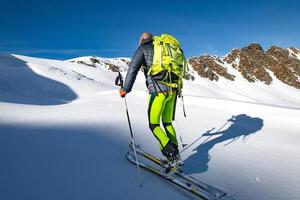 grimper avec des skis et des peaux de phoque dans la neige vierge