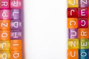 de nombreux cubes décoratifs colorés avec des lettres sur fond blanc. photo