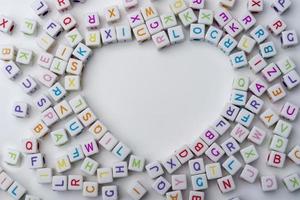 de nombreux cubes décoratifs colorés avec des lettres sur fond blanc. photo