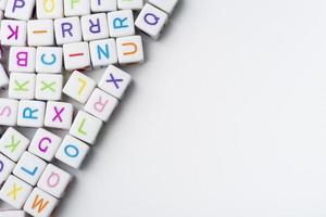 de nombreux cubes décoratifs colorés avec des lettres sur fond blanc. photo