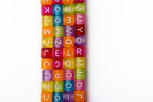 de nombreux cubes décoratifs colorés avec des lettres sur fond blanc. photo