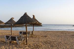 transats vides sur une plage tropicale. chaises longues sur la plage de sable au bord de la mer. vacances d'été et concept de vacances pour le tourisme.